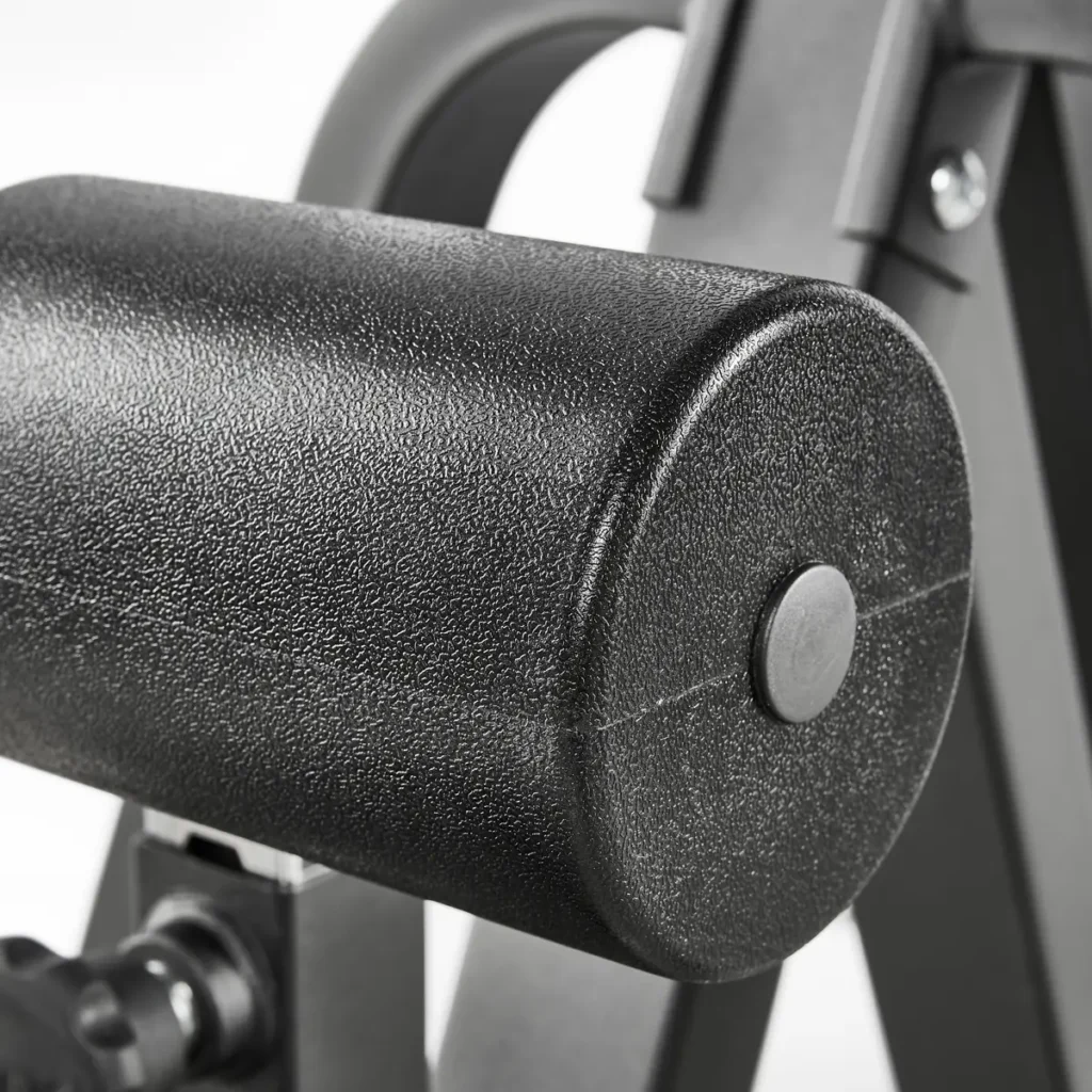 Close-up of a textured cylindrical black cushion on the ATX® Cable Lat Pull Down Machine, supported by a metal structure with part of the machine’s frame in the background.