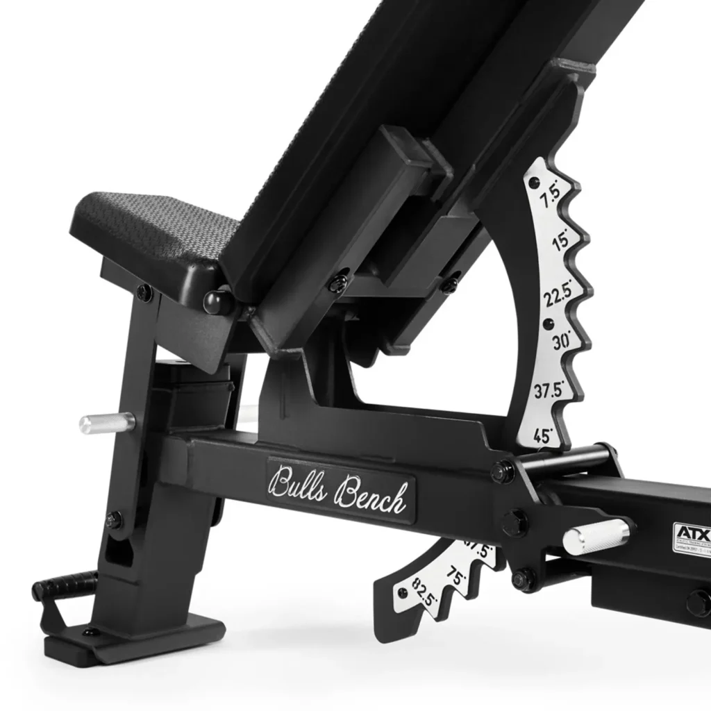Close-up of an adjustable workout bench with ATX® Warrior Bench - Slim PU (Copy) labeled. It features a mechanism for various incline settings, and its black and metallic design highlights robust construction.