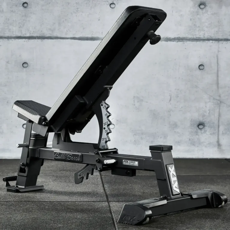 The ATX® Warrior Bench - Slim PU (Copy) sits on a dark gym floor against a concrete wall backdrop, featuring a padded seat and backrest with clearly visible numerical adjustments for incline settings.