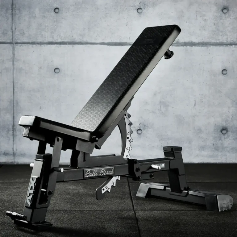 An ATX® Warrior Bench - Slim PU, featuring a cushioned backrest and seat, metal frame, and adjustable incline, is positioned against a gray concrete wall.