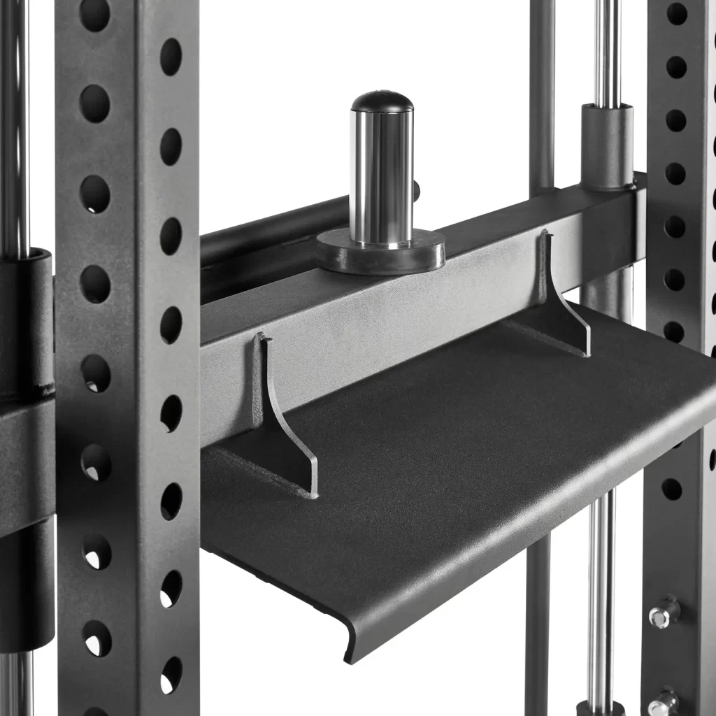 Close-up of a gym machines pulley system, featuring a metal frame with multiple holes, a metal handle, and a flat weight platform. The setup suggests adjustable features for weightlifting exercises.