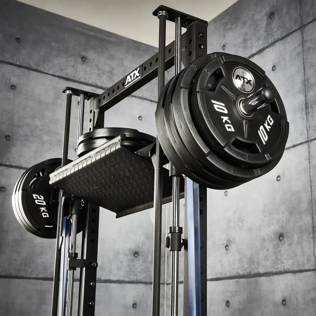 A squat rack is equipped with multiple 10 kg and 20 kg weight plates on each side. The background features a concrete wall with a grid pattern. The rack has a sturdy, metallic frame suitable for strength training exercises.
