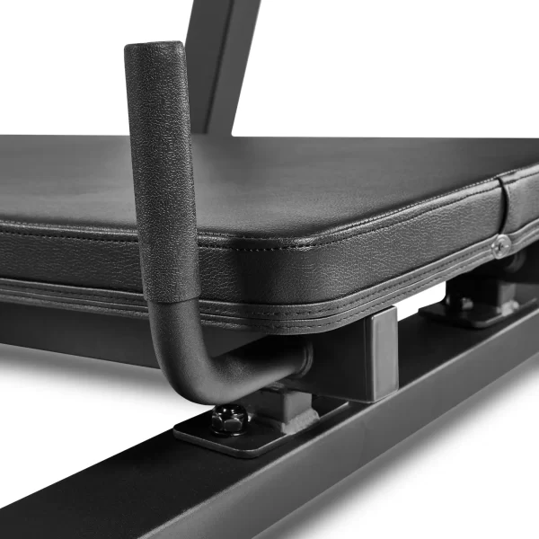 Close-up of a black gym bench with padded upholstery and a sturdy metal frame. The image shows a handle attached to the side, designed for support or lifting. The bench surface is smooth and well-cushioned.